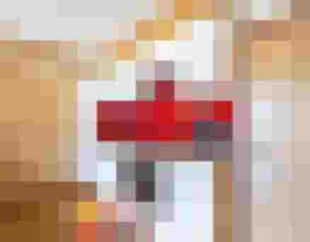 weiße Küchenzeile mit roter Rückwand, Herd, Spüle und Geräten zwischen zwei Holztüren